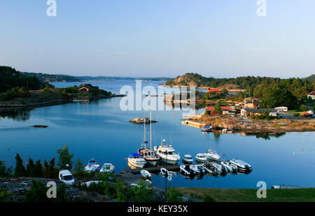 KRISTIANSAND, NORVEGIA, IL 1° LUGLIO 2009. Vista su ponti, barche e Lodge vicino a un piccolo porto. Serate estive tranquille. Editoriale. Foto Stock