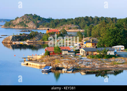 KRISTIANSAND, NORVEGIA, IL 1° LUGLIO 2009. Vista su ponti, barche e Lodge vicino a un piccolo porto. Serate estive tranquille. Editoriale. Foto Stock