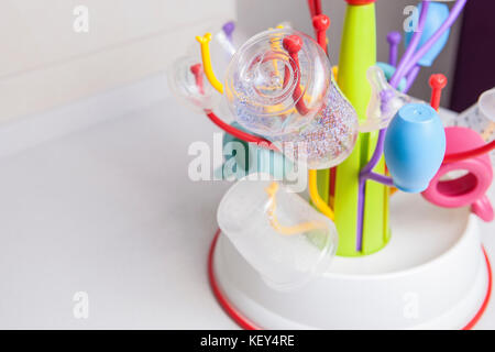 Baby sgocciolatoio pieno di stoviglie di plastica oggetti come biberon, Aspiratore nasale, latte bocce, tettarelle e altri Foto Stock