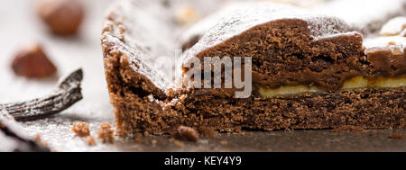 Torta al cioccolato torta guarnita con nocciole e spolverati con zucchero a velo Foto Stock