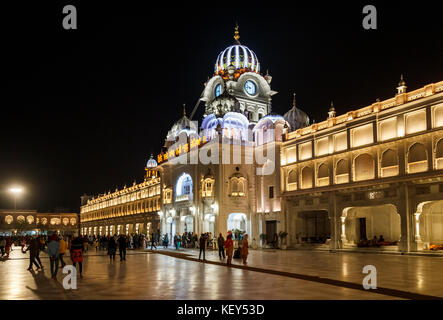 La facciata esterna del tempio d'oro di Amritsar illuminata di notte, il santissimo Gurdwara e luogo di pellegrinaggio del sikhismo, Amritsar Punjab, India Foto Stock