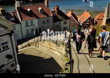 I turisti salire la ripida passi di Abbazia, 199 in totale, che conduce dal porto di Abbazia a Whitby, Yorkshire. Foto Stock