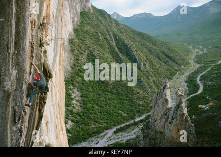 Fotografia di avventuroso rocciatore arrampicata su roccia Celestial Omnibus (5.12a) salendo rout a El Porterio Chico, a Monterrey, Messico Foto Stock