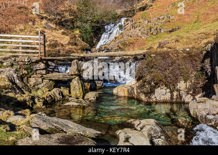 Cascate e ardesia ponte di pietra sul Afon (Fiume) Cwm Llan mostra piscina turchese vicino al percorso Watkin a Mount Snowdon Parco Nazionale di Snowdonia Foto Stock