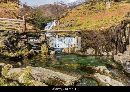 L'ardesia ponte di pietra sul Afon (Fiume) Cwm Llan mostra piscina turchese e cascate vicino al percorso Watkin a Mount Snowdon Parco Nazionale di Snowdonia Foto Stock