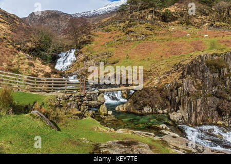 L'ardesia ponte di pietra sul Afon (Fiume) Cwm Llan mostra piscina turchese e cascate vicino al percorso Watkin a Mount Snowdon Parco Nazionale di Snowdonia Foto Stock