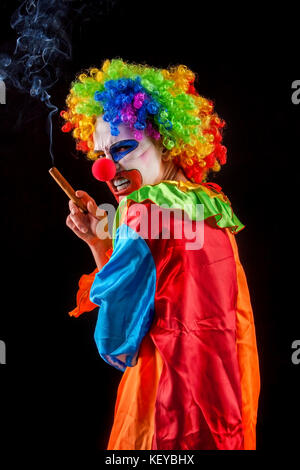 Halloween evil clown su sfondo nero. ritratto di donna di fumo. Foto Stock