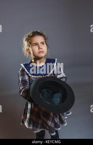 La ragazza con il cappello in mano per chiedere delle monete in euro Foto Stock