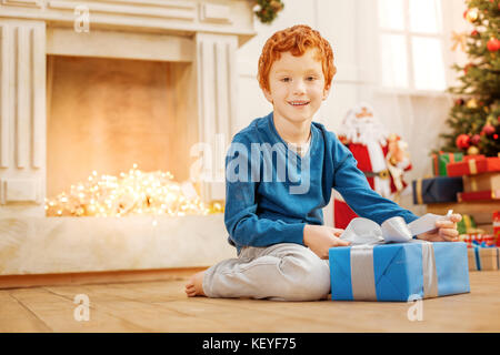 Emozionato bambino ottenere pronto ad aprire il regalo di natale Foto Stock