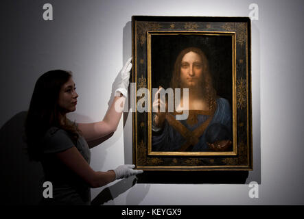 Un dipendente adegua Leonardo da Vincis Salvator Mundi a Christies a Londra prima che il lavoro venga venduto nel Post-War e Contemporary Art Evening Auction il 15 novembre a Christies New York, dove si stima che sia nell'ordine di 100 milioni di dollari. Foto Stock