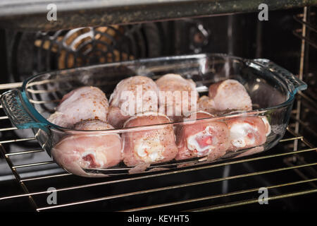 Le cosce di pollo sono cotti in forno in una forma di vetro Foto Stock