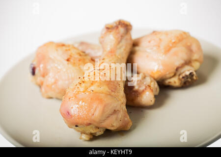 Cosce di pollo al forno con pepe e spezie su una piastra Foto Stock
