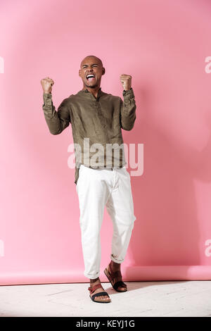 Lunghezza completa immagine di felice urlando africano su sfondo rosa Foto Stock