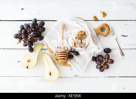 Formaggio Camembert con l'uva, le noci, pera e miele su vintage piastra in metallo Foto Stock