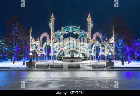 Decorare le strade della città e alberi con decorazioni di luce per il Natale e il nuovo anno Foto Stock
