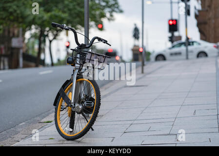 Una delle molte nuove biciclette a noleggio disponibile in Sydney sta aspettando di essere affittato Foto Stock