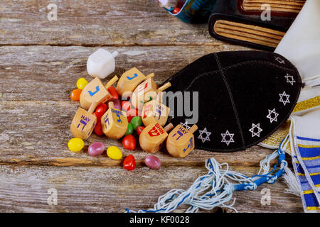 In legno di filatura dreidels top per hanukkah festa ebraica su glitter Sfondo legno Foto Stock