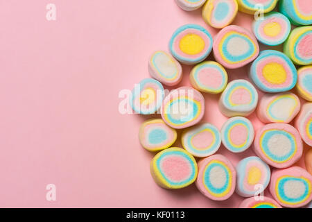Minima laici piana. vista dall'alto del pastello marshmallows su un pinkbackground. Foto Stock