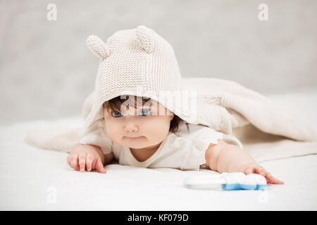 Ritratto di bambina strisciando sulla coperta in ambienti interni Foto Stock