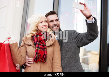 Uomo di scattare una foto durante lo shopping Foto Stock