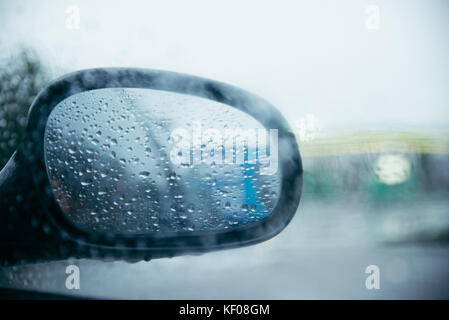 Le gocce di pioggia sulla vettura specchietto retrovisore. heavy rain al di fuori Foto Stock