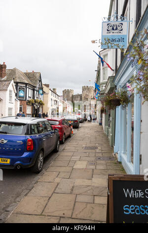 Conwy town high street scene, castello in background Foto Stock