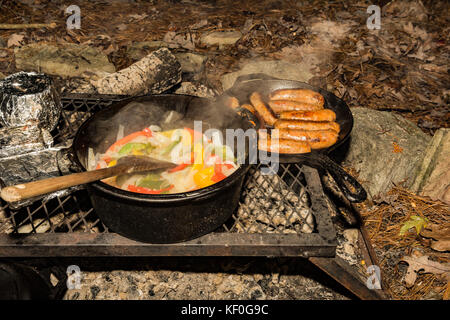 La cottura di una salsiccia verdure sul fuoco. Foto Stock