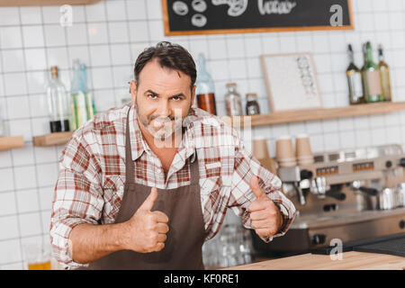 Il barista che mostra pollice in alto Foto Stock