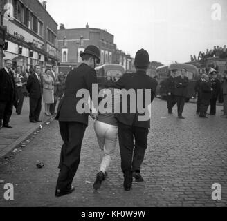 Saldamente afflitto da due poliziotti, un uomo viene rimosso dalla riunione del movimento sindacale di Sir Oswald Mosley a Ridley Road, Dalston, Londra. Foto Stock