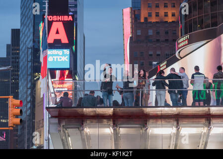 Molte persone godendo di una vista serale in new york città times square quartiere dello shopping. Foto Stock