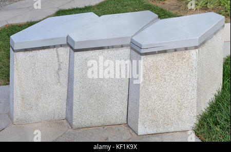 La città moderna di una panchina nel parco è costituito di pezze esagonali con granito e legno Foto Stock