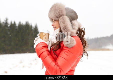 Donna felice in inverno cappello di pelliccia con caffè all'aperto Foto Stock