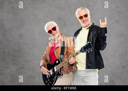 Coppia senior con guitar mostra rock segno a mano Foto Stock