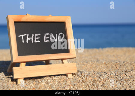 Lavagna con 'Fine' testo sulla spiaggia Foto Stock