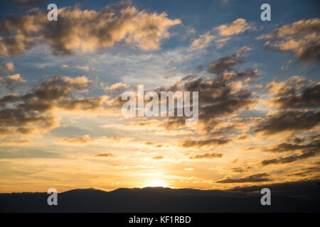 Vista panoramica di un bel tramonto sopra il nero sagome delle montagne Foto Stock