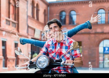 I turisti facendo gita turistica a Berlino su vespa Foto Stock