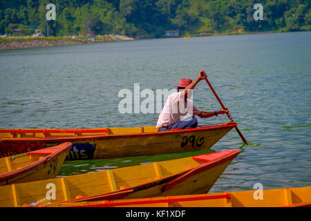 Pokhara, nepal - Novembre 04, 2017: close up dell'uomo paddling il giallo barca al lago Begnas in pokhara, Nepal Foto Stock