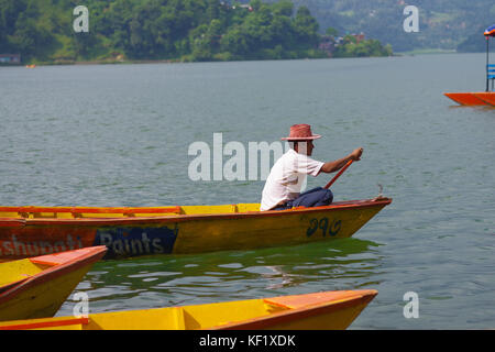 Pokhara, nepal - Novembre 04, 2017: close up dell'uomo paddling il giallo barca al lago Begnas in pokhara, Nepal Foto Stock