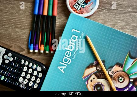 Libro di matematica sull'algebra sulla scrivania accanto ai materiali dell'aula Foto Stock