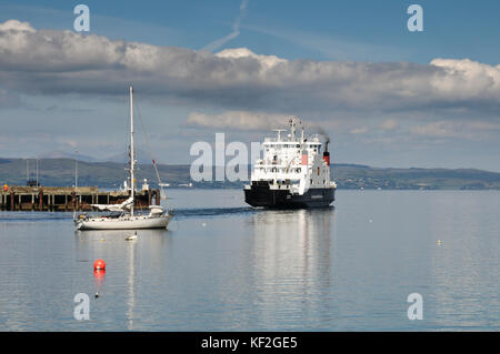 Vista attraverso le acque ancora di mallaig porto sulla scottish west coast in estate con barche ormeggiate, un traghetto per le isole e cielo blu Foto Stock