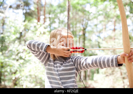 Ragazza tiro con arco e frecce nella foresta Foto Stock