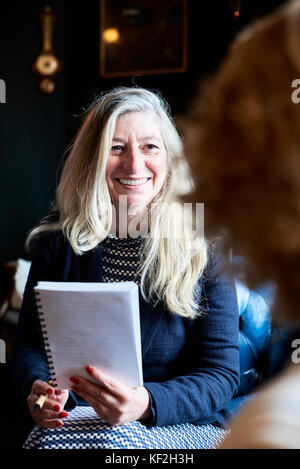 Londra, UK, elegante senior business donna sorridente al suo business partner in possesso di un notebook, senior business donne Foto Stock