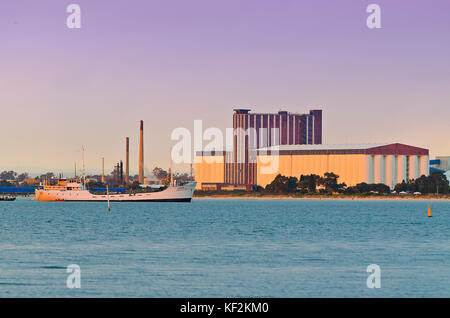 White Ship al di ancoraggio in porto tranquillo nelle prime ore del mattino con kwinana di cereali alla rinfusa facilità di manipolazione in background Foto Stock