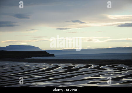 Tramonto luce di riflessione modelli sulla sabbia con vista oceano blu e nuvola orizzonte a mezzanotte sole ora a Miklavatn, Skagafjordur, Islanda del Nord Foto Stock