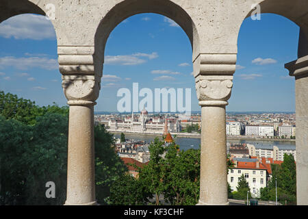 Parlamento ungherese e il Danubio attraverso archi Bastione del Pescatore del Quartiere del Castello di Buda superiore Budapest Ungheria Foto Stock