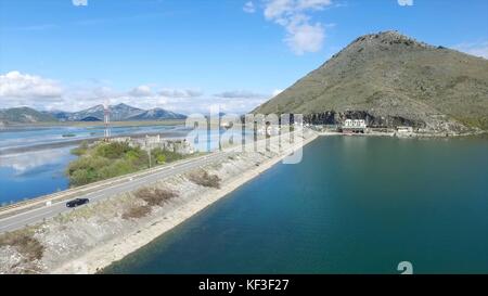 Nero auto la guida sul ponte blu del mare, delle montagne e del cielo sfondo. riprese. vettura andando su una strada vicino al fiume, vista aerea. le riprese. vista aerea al piccolo lago di foresta e la linea di autostrada passando vicino a. Foto Stock