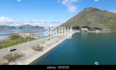 Auto nera che guida sul mare blu, sulle montagne e sullo sfondo del cielo. Riprese. Auto che va su una strada vicino al fiume, vista aerea. Riprese. Vista aerea sul piccolo lago forestale e sulla linea di autostrada che passa nelle vicinanze. Foto Stock