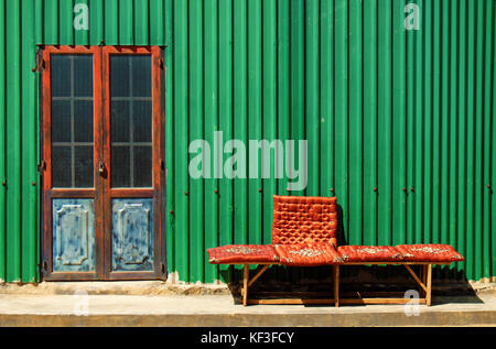 Abstract facciata casa con muro di ferro, verde lamiera rendere piacevole esterno della casa, porta rossa della serratura e bancone di casa Foto Stock