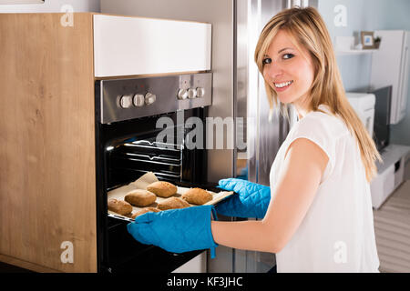 Giovane donna sorridente tenendo teglia da forno a microonde Foto stock -  Alamy
