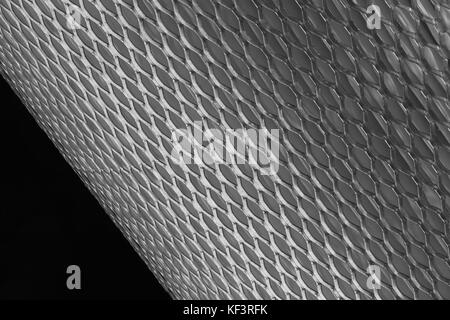 Maglie di metallo per filtro in rotolo su uno sfondo nero Foto Stock